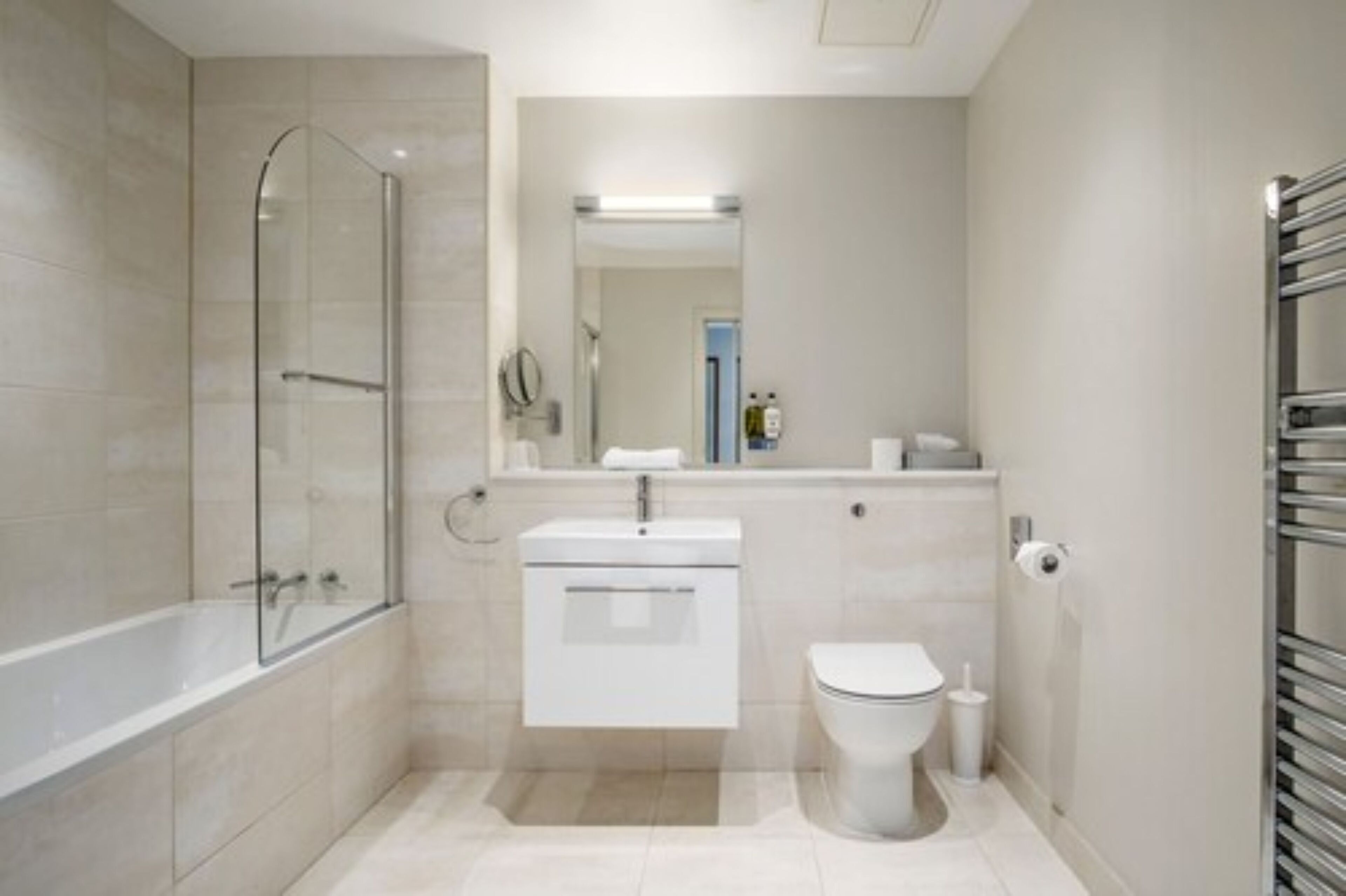 A modern bathroom with a glass-enclosed shower, a white sink, and a toilet.
