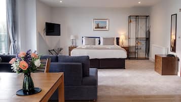 Una habitación de hotel moderna con cama, escritorio, sofá y televisión.