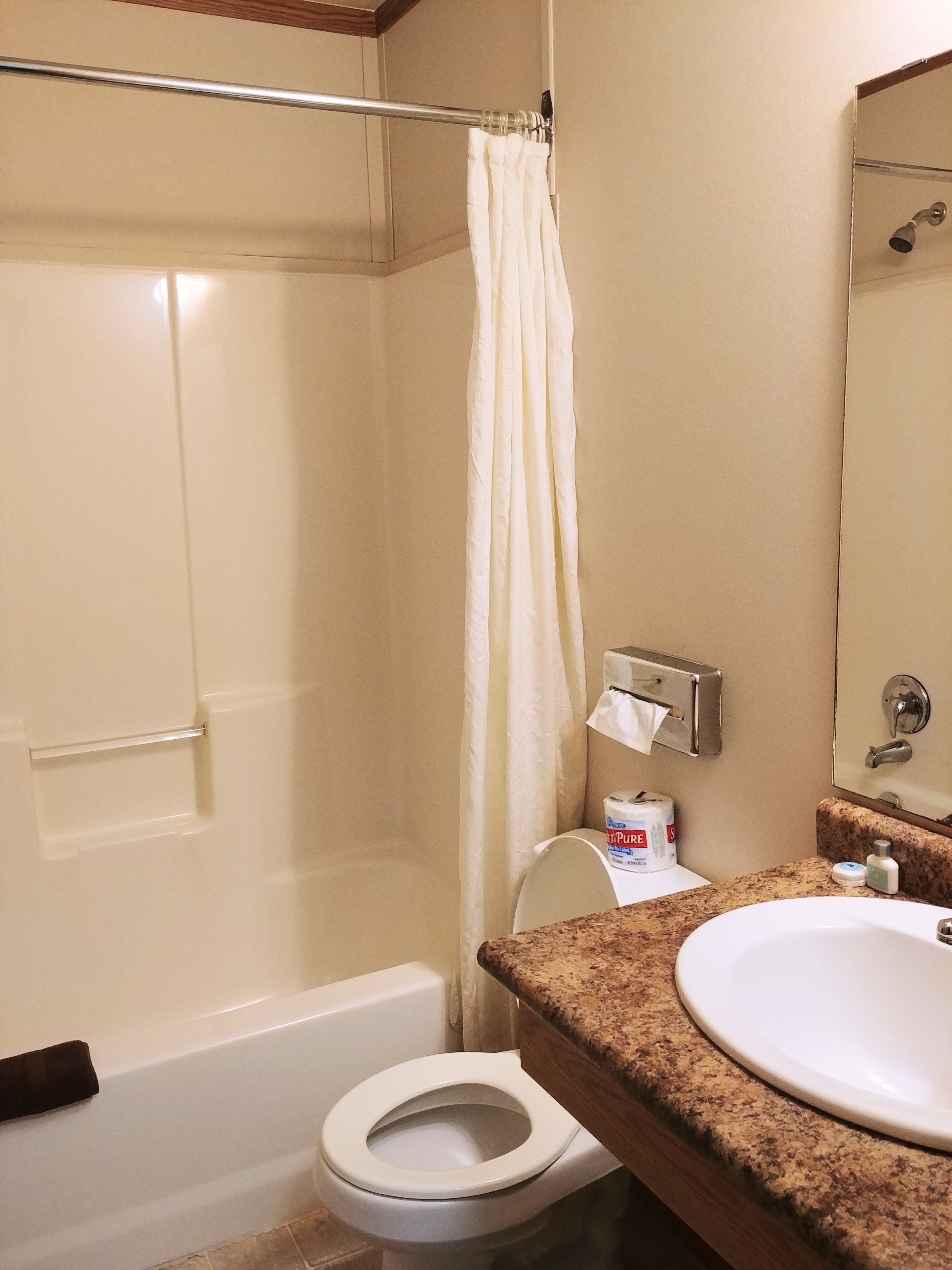A bathroom with a bathtub, toilet, and sink.