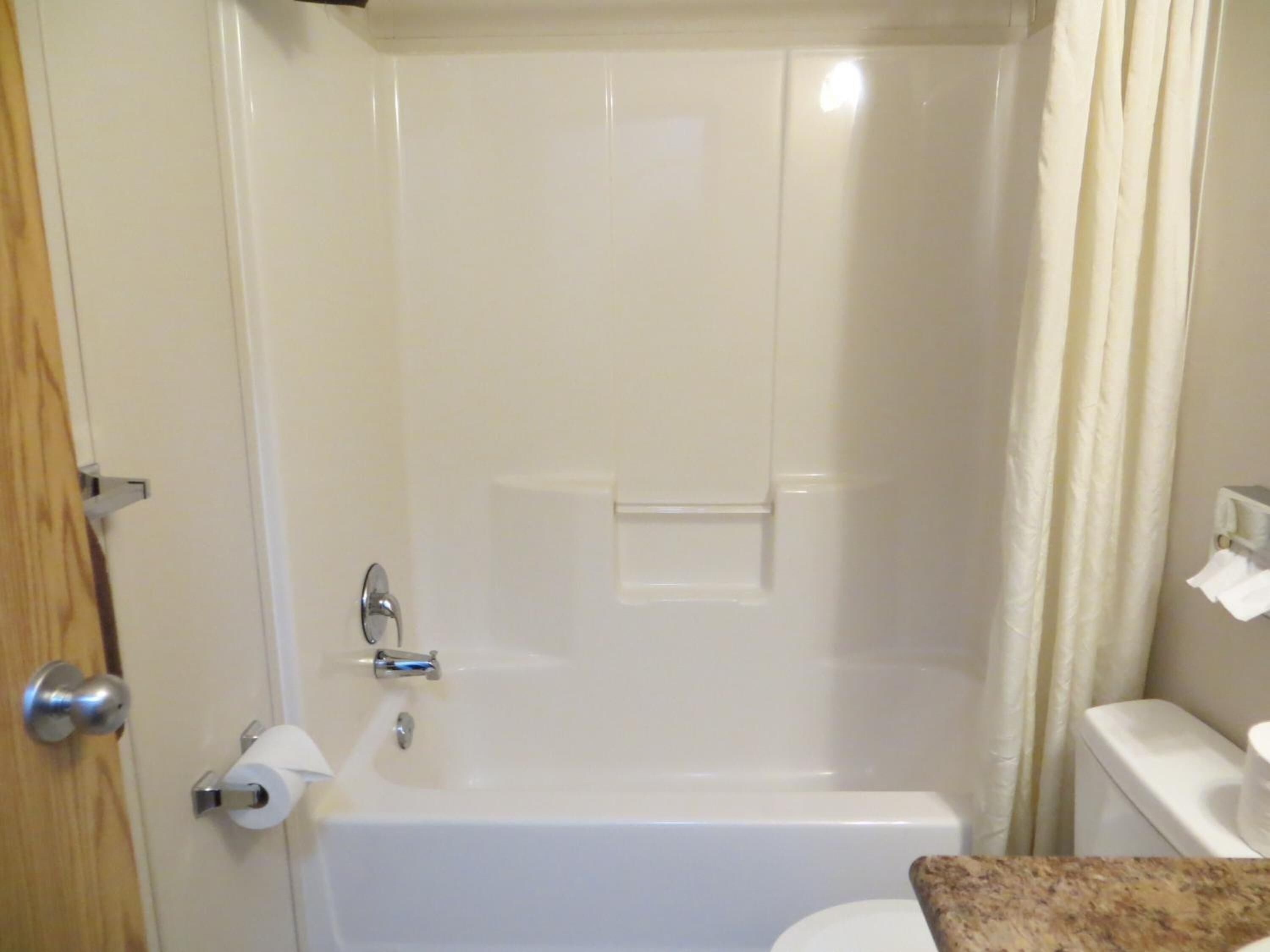 Un baño con bañera, inodoro y cortina de ducha.