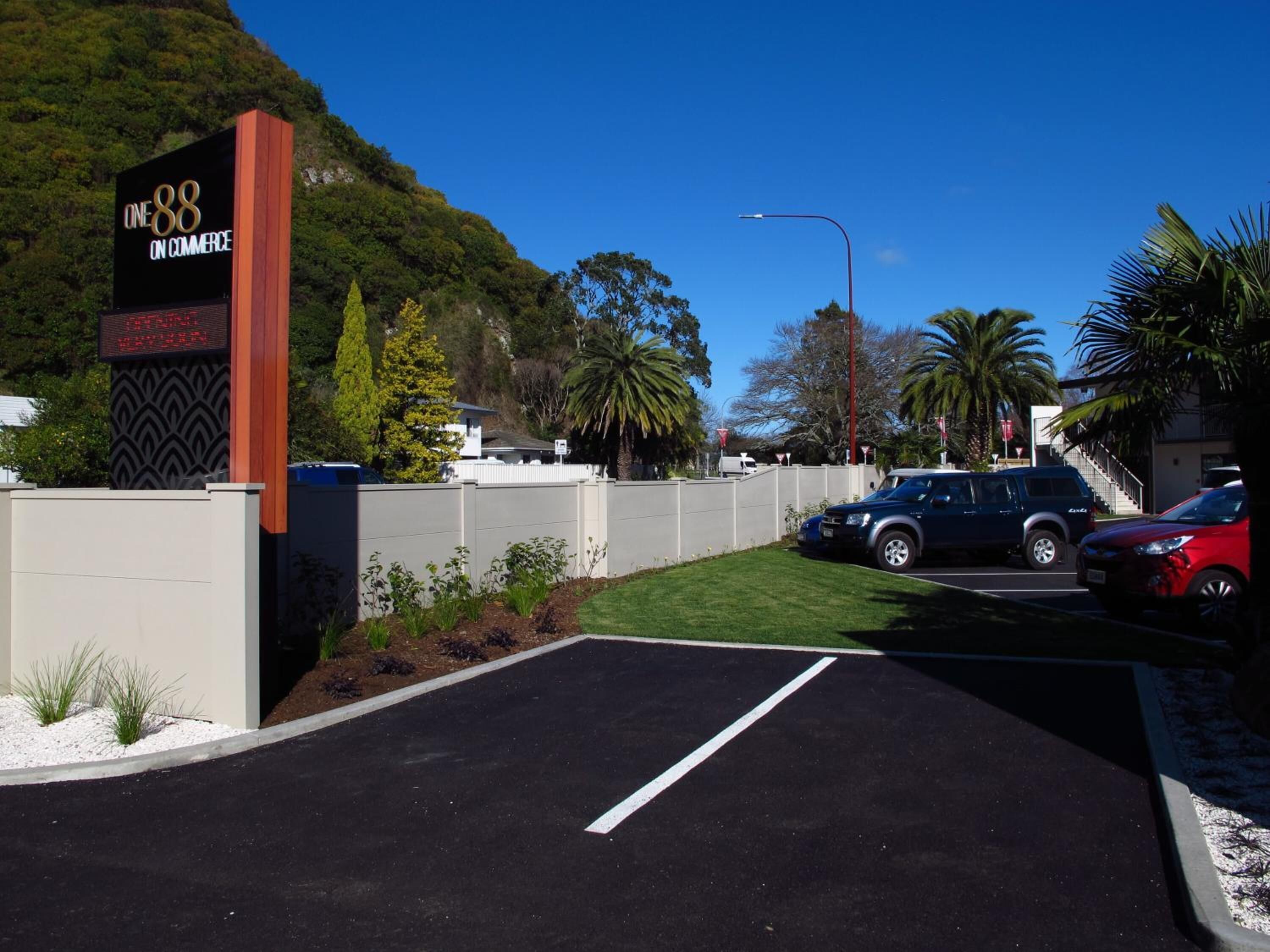 A parking lot with cars, a sign for 'Cine88 on Commerce', and a hilly background.
