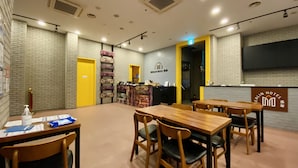 A hotel lobby with a reception desk, multiple seating areas, and a large screen displaying the hotel name. - Myeongdong Merlin Hotel (Seoul)