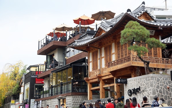 A traditional wooden building with multiple balconies and outdoor seating areas.