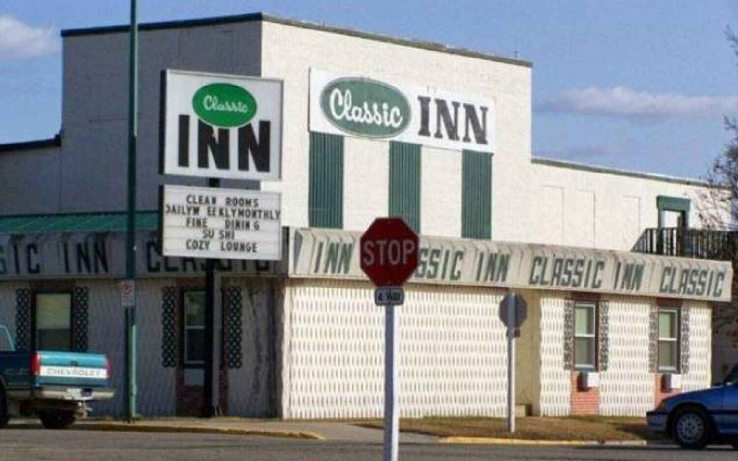A Classic Inn building with a sign indicating clean rooms, daily early monthly fine dining, sushi, and a cozy lounge.