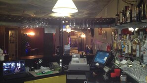 A bar area with a counter, multiple screens, and a variety of bottles. - Classic Inn (Melville)