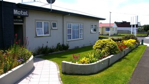 Un motel doté d’une réception, d’un chemin pavé et de parterres de fleurs.