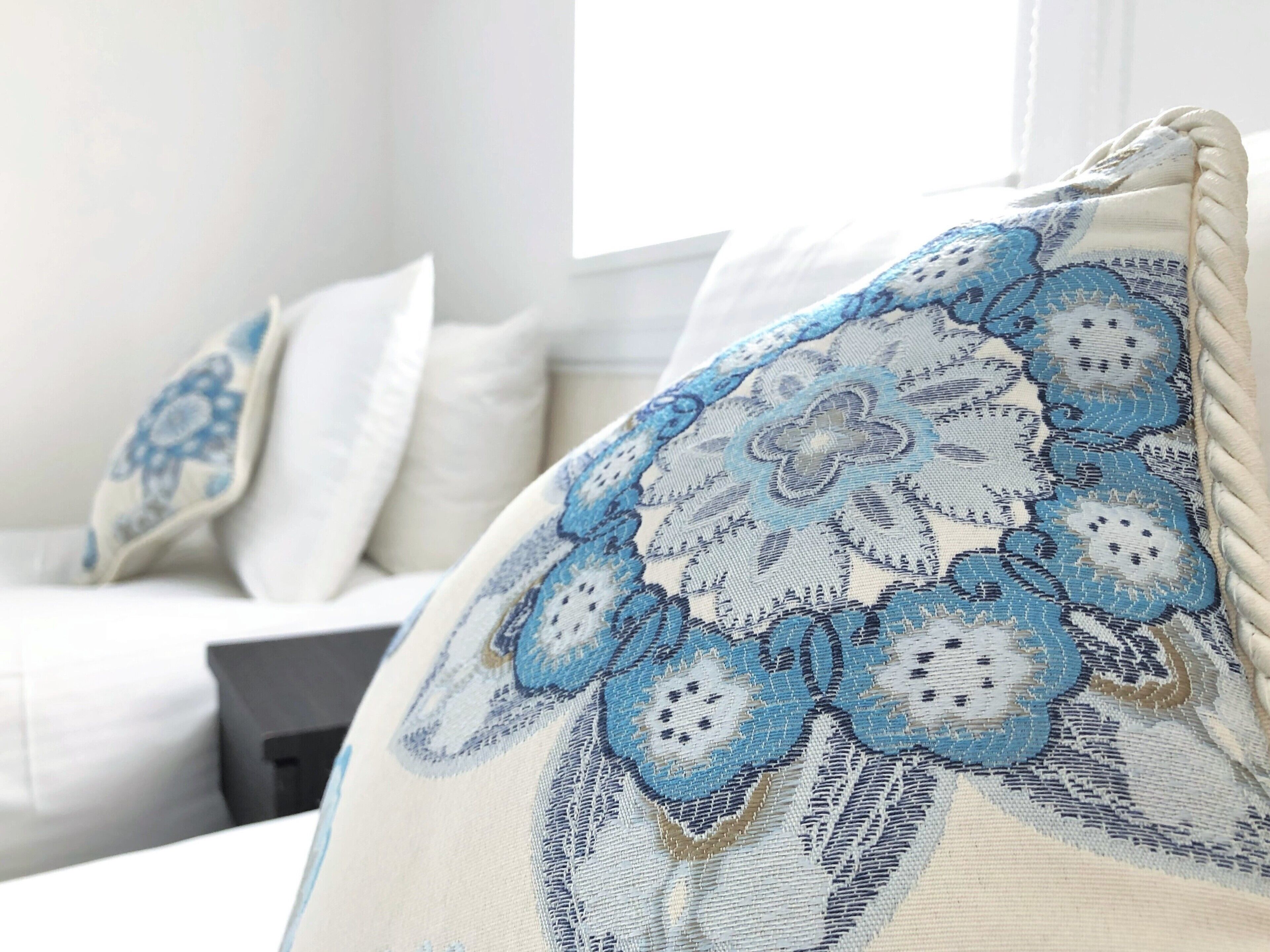 A close-up of a pillow with a blue and white floral pattern.