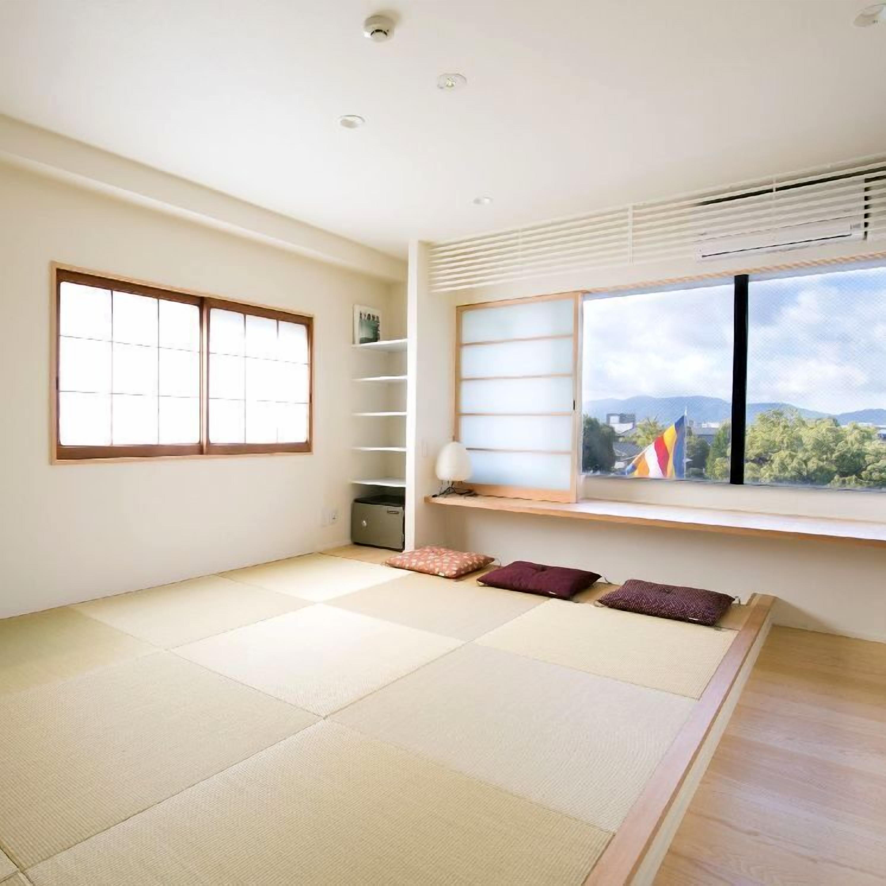 Habitació amb paviment de tatami, un panell corredís shoji, una petita prestatgeria i una finestra amb vista a les muntanyes.