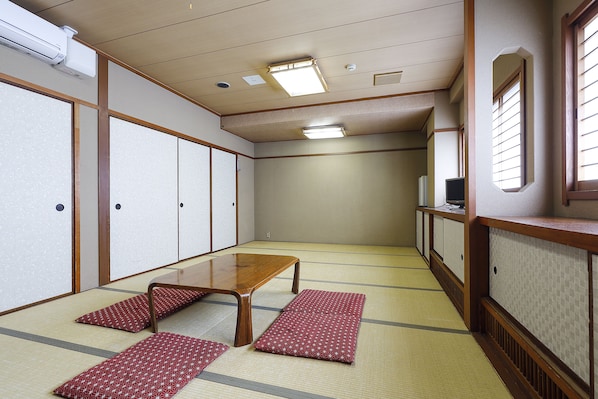Perinteinen japanilainen huone, jossa on tatamimatto, matala puupöytä ja liukuseinät.