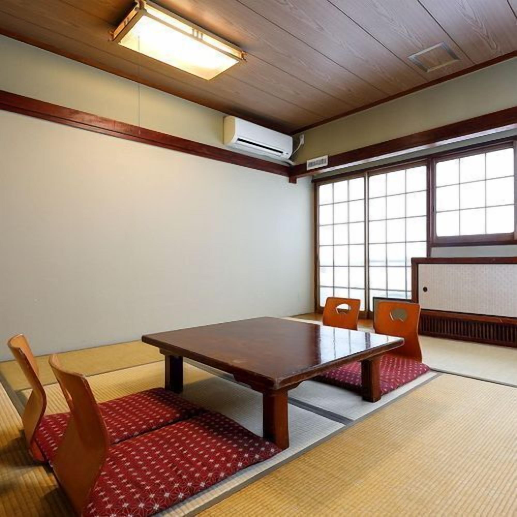 Una habitació japonesa tradicional amb fons de tatami, una taula de fusta baixa i panells shoji.
