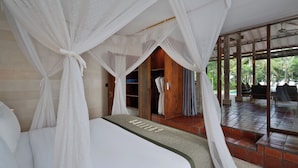 Un dormitorio con cama con dosel, un armario de madera y vistas a una zona de piscina.