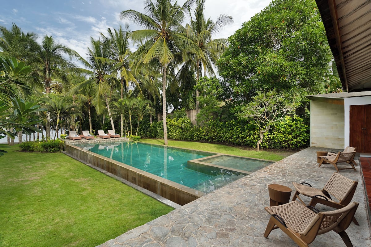 A swimming pool with lounge chairs and a stone deck.