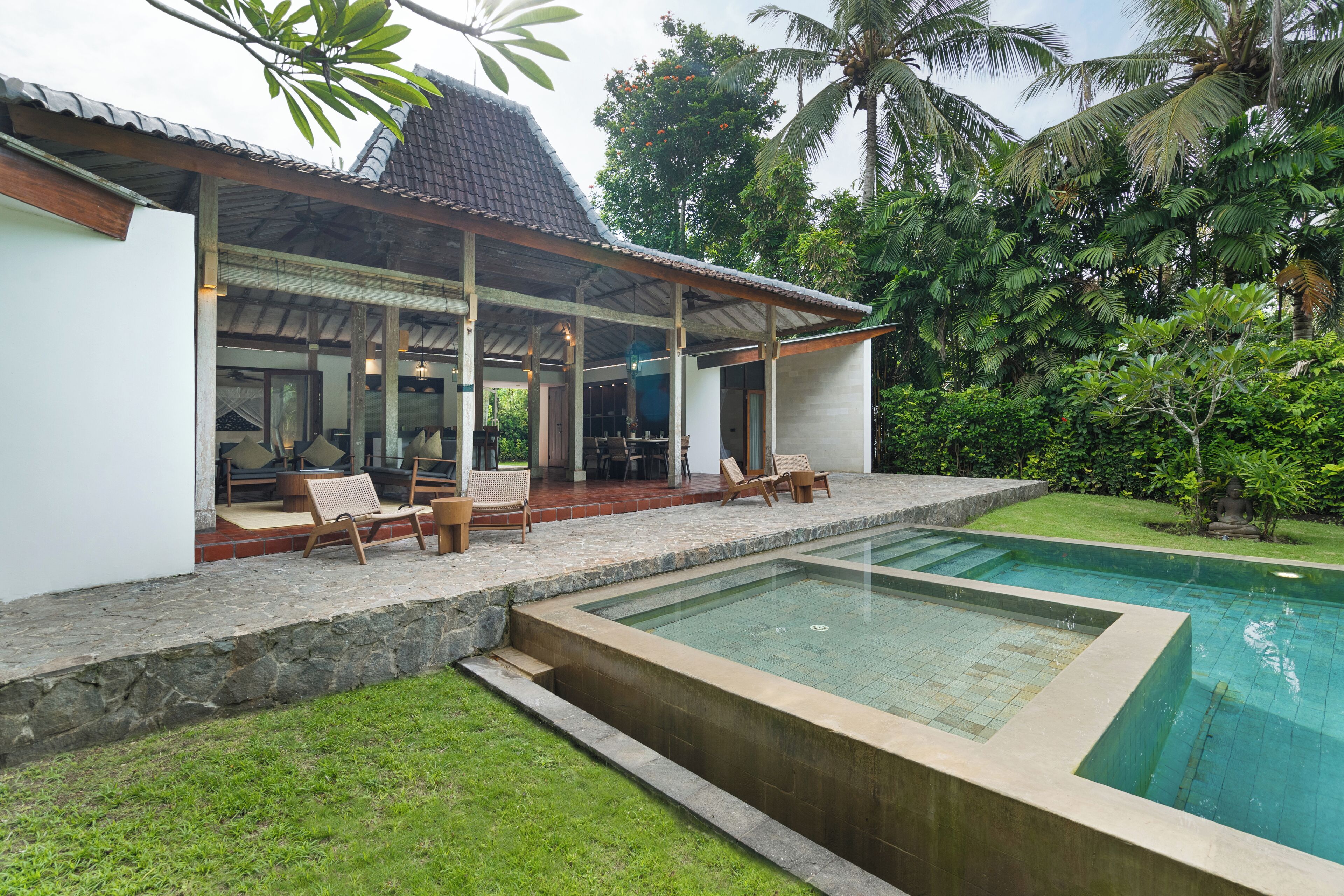 A poolside area with a covered seating area and a pool.