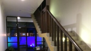 A modern living room with a staircase, a sofa, and a dining area. - Sunrise Palace (Negombo)