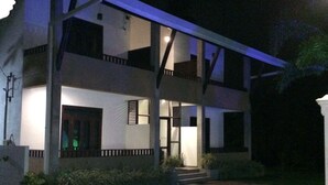 A two-story building with a balcony on the upper floor, a covered entrance, and a paved driveway. - Sunrise Palace (Negombo)