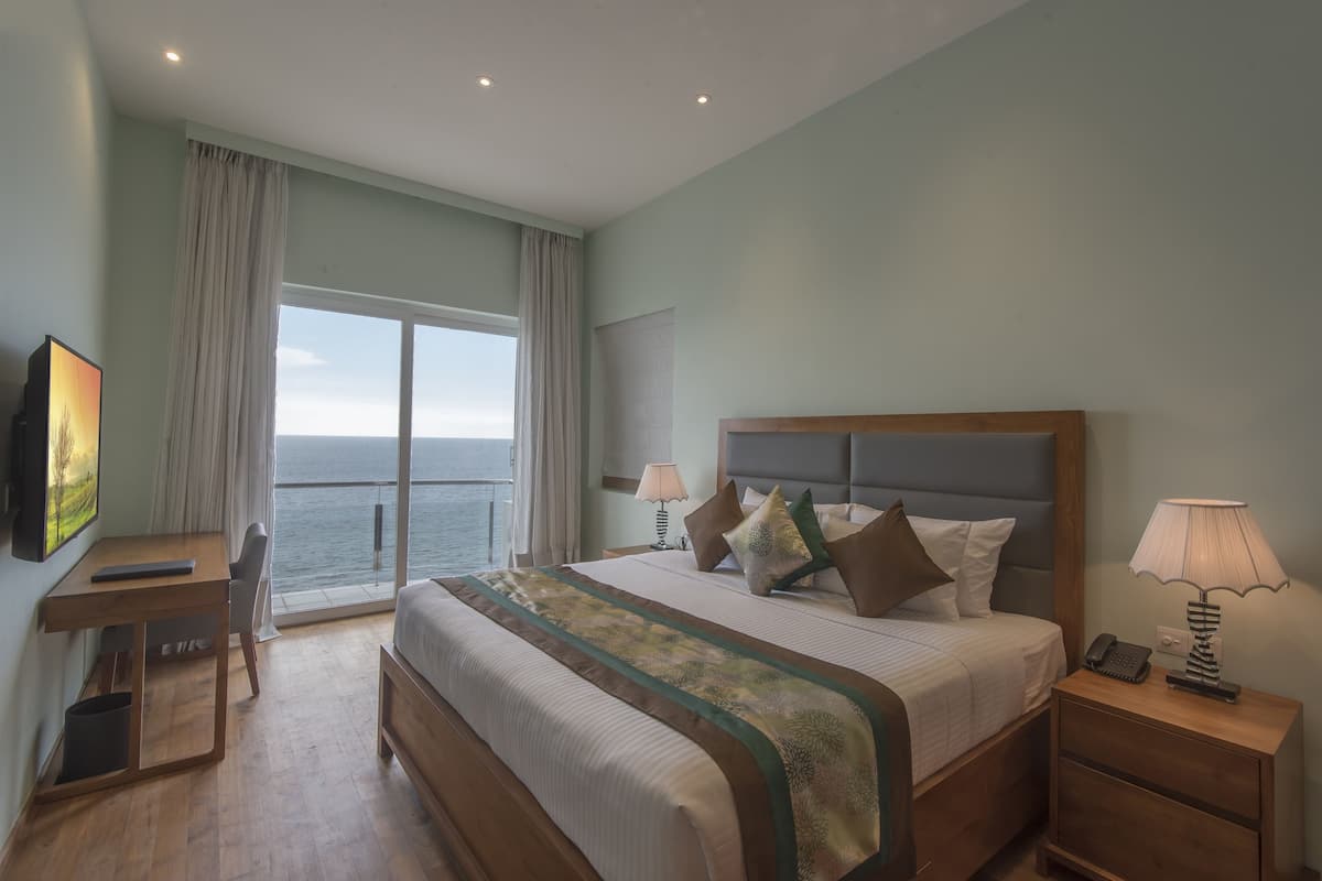 Une chambre à coucher avec un grand lit, un bureau, une chaise, une table de chevet et un téléviseur.