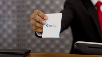 A person holding a business card with "Ocean Edge Colombo Sri Lanka" printed on it.