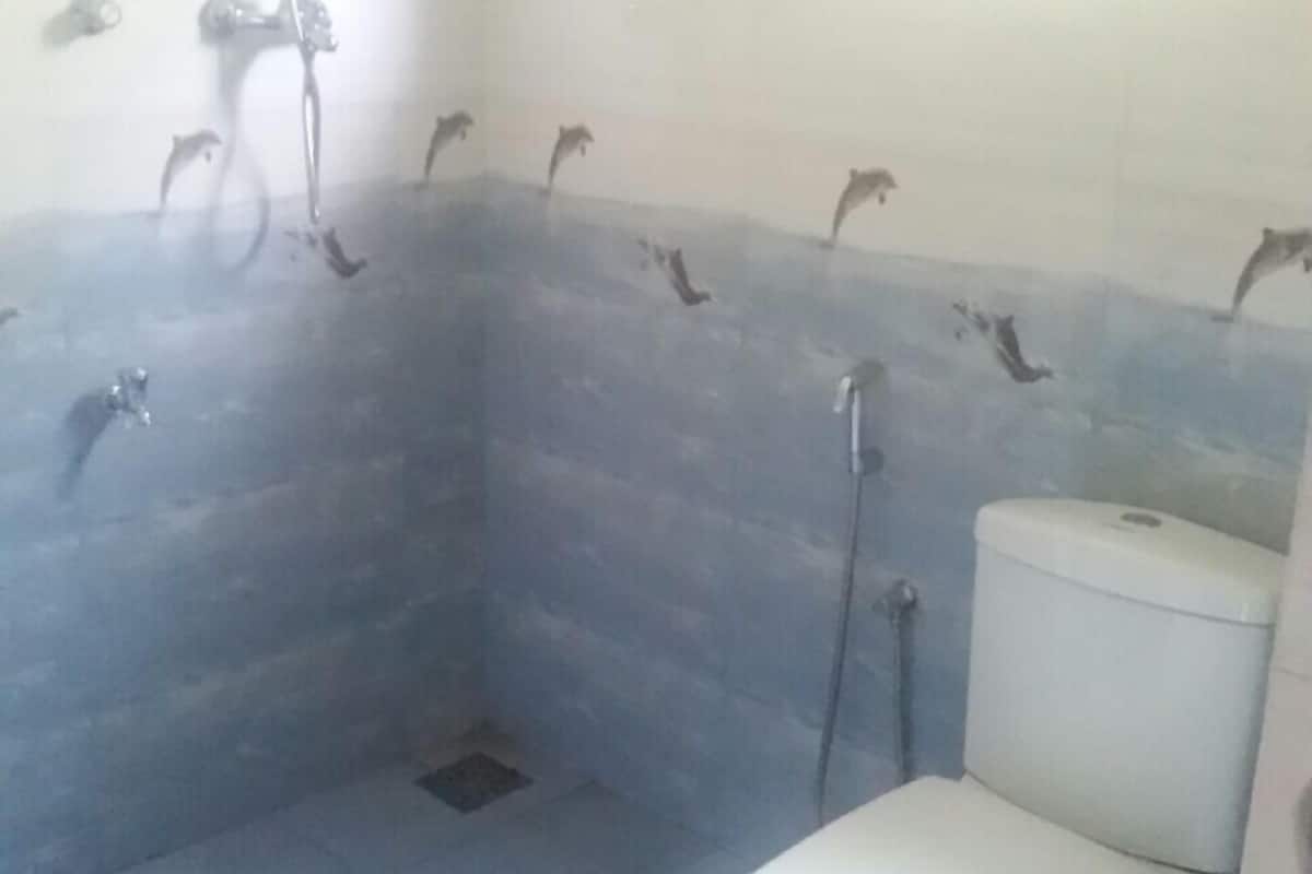 A bathroom with a shower, toilet, and a wall-mounted sink.