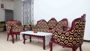 A room with a sofa set, a table with a lace tablecloth, and a ceiling fan. - Akash Villa (Thalaramba)