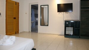 A hotel room with a bed, a TV, a minibar, and a bathroom visible through an open door. - Hôtel Medina (Sousse)