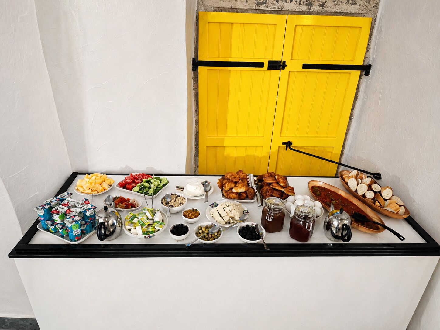 Una mesa de buffet con diversos alimentos y salsas.
