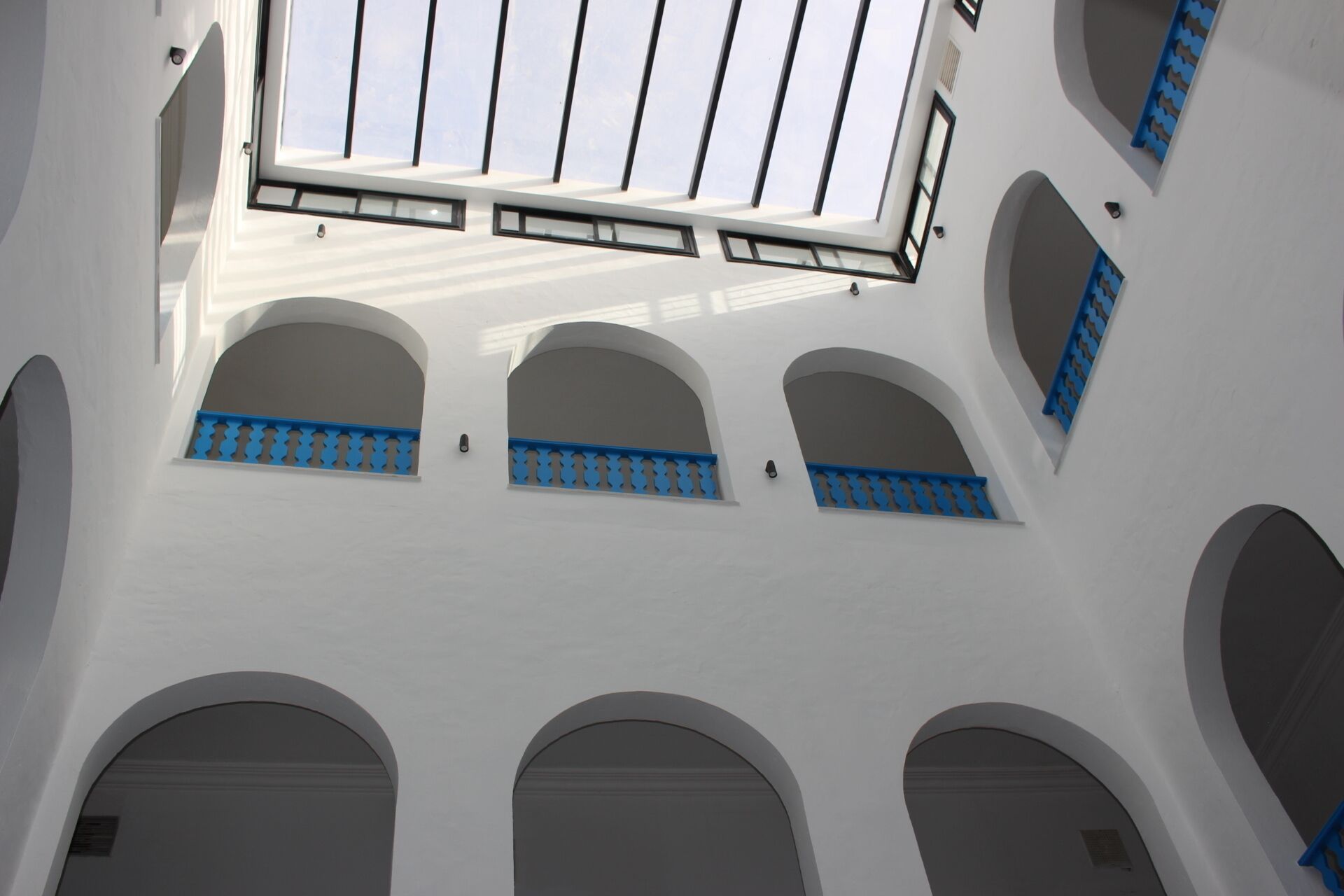 Edifici amb diverses finestres allargades i balcons, amb un fanal central.