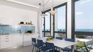 Eine moderne Küche mit Essbereich, großen Fenstern und Meerblick.