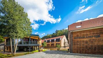 A modern building with a wooden garage door labeled "KORNKAMMER" and a glass entrance.