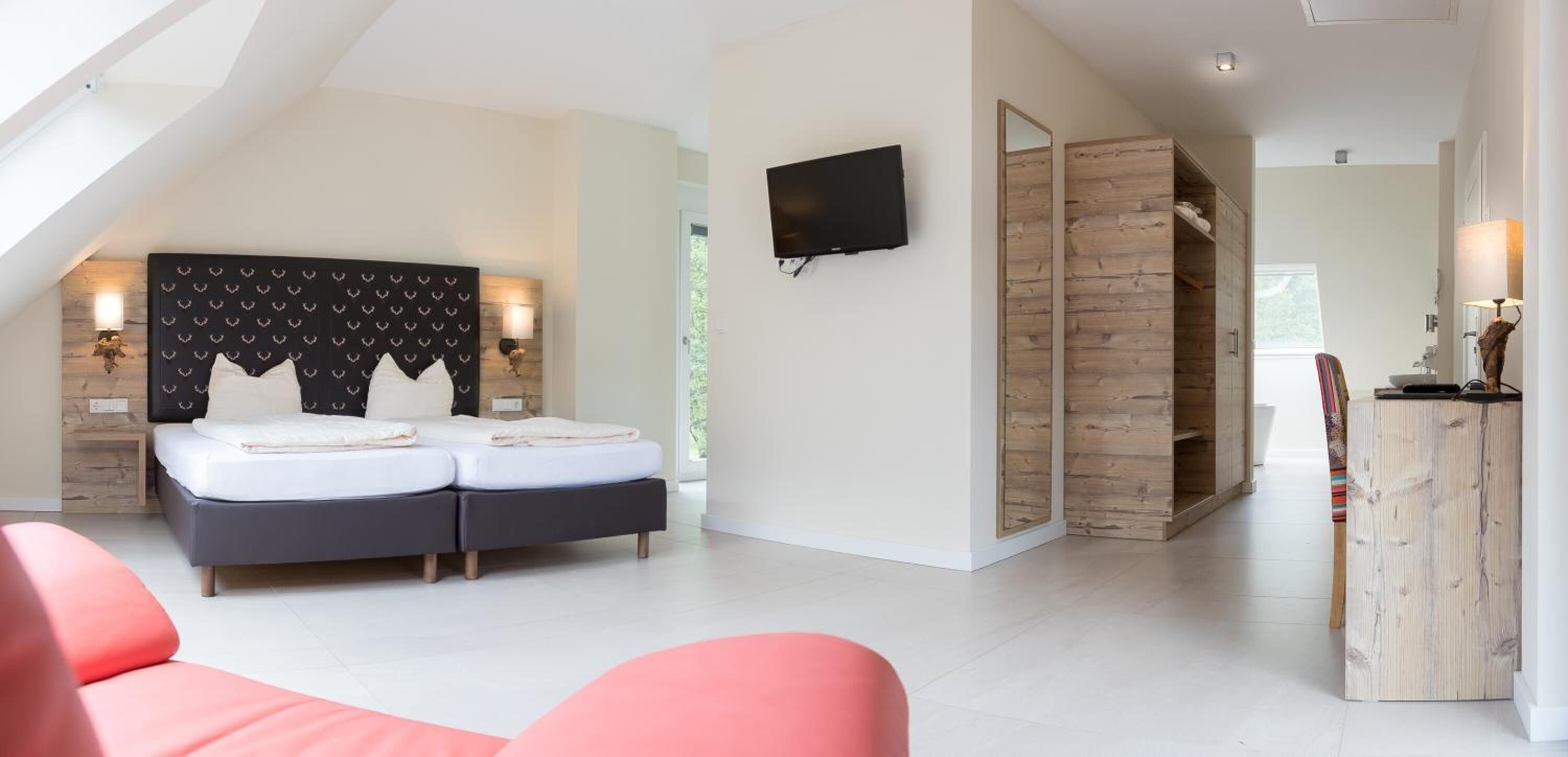 Un dormitorio moderno con cama, televisor y armario de madera.