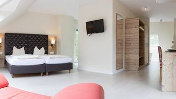 Un dormitorio moderno con cama, televisor y armario de madera.