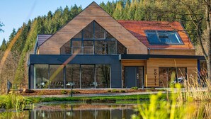 A modern hotel with a wooden facade, large windows, and a red-tiled roof. - Landhotel Weihermühle (Herschberg)