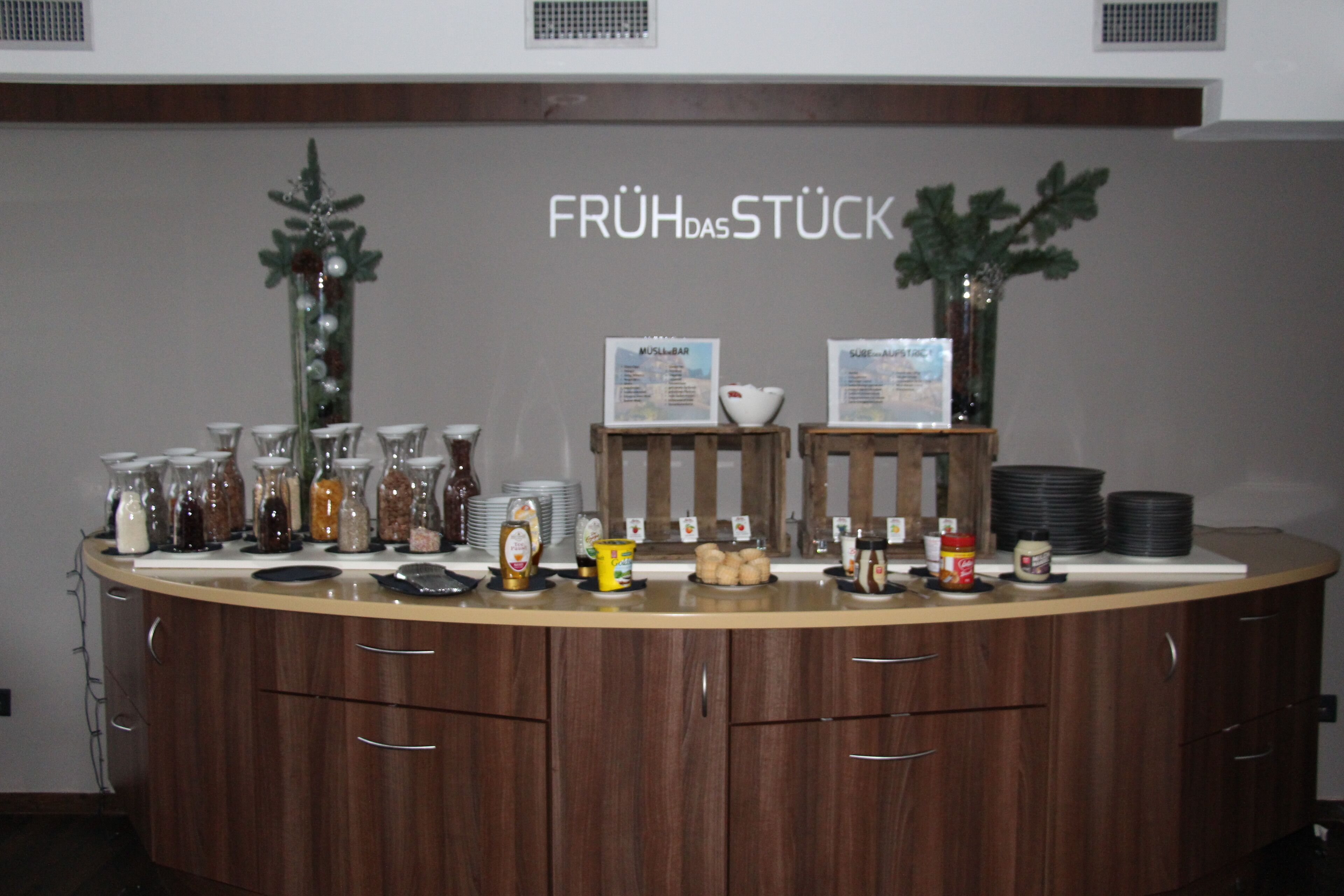 Ein Frühstücksbuffet mit Gewürzregalen, einer Kaffeemaschine und einer Speisekarte.
