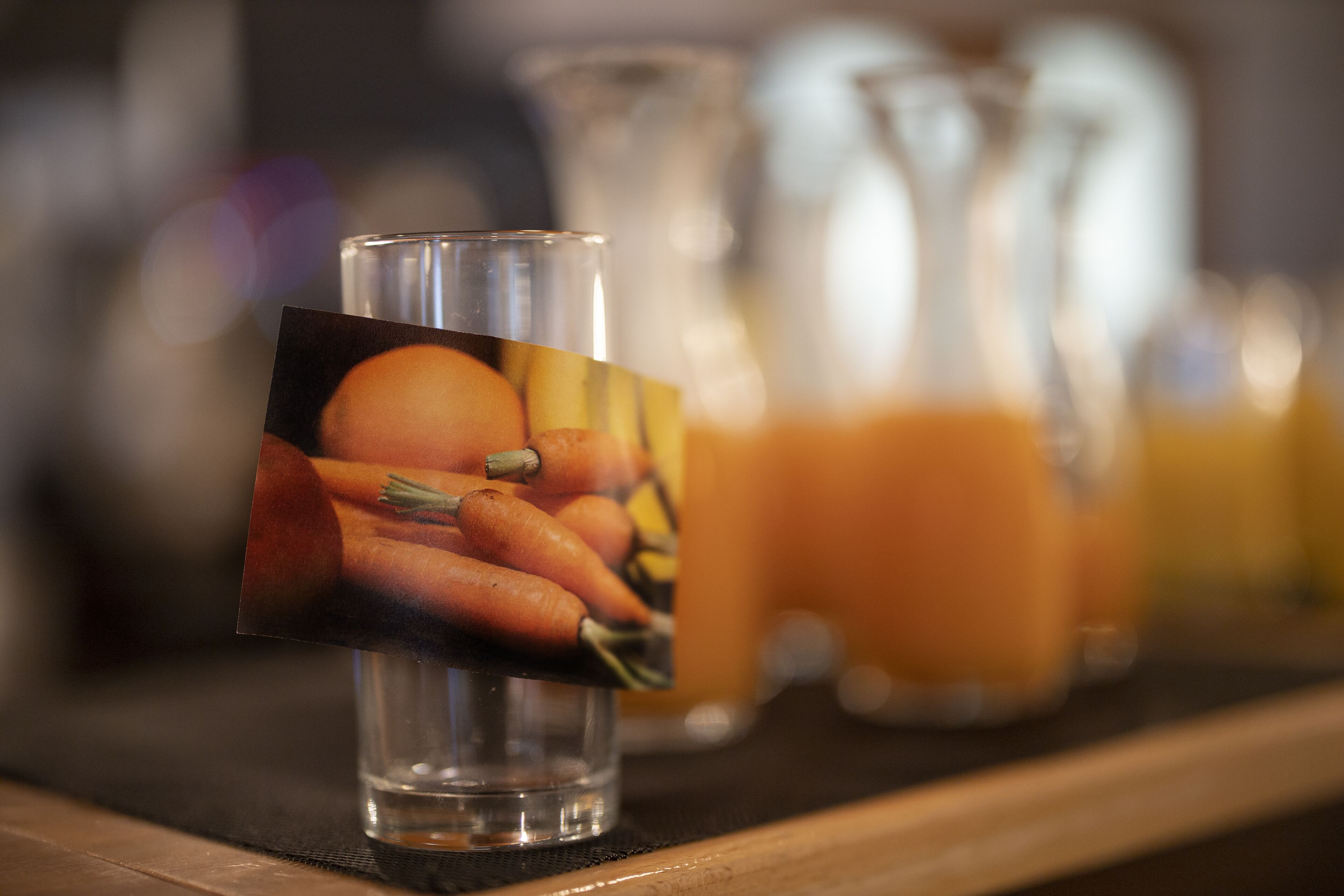 Een glas met een afbeelding van wortels op een tafel.