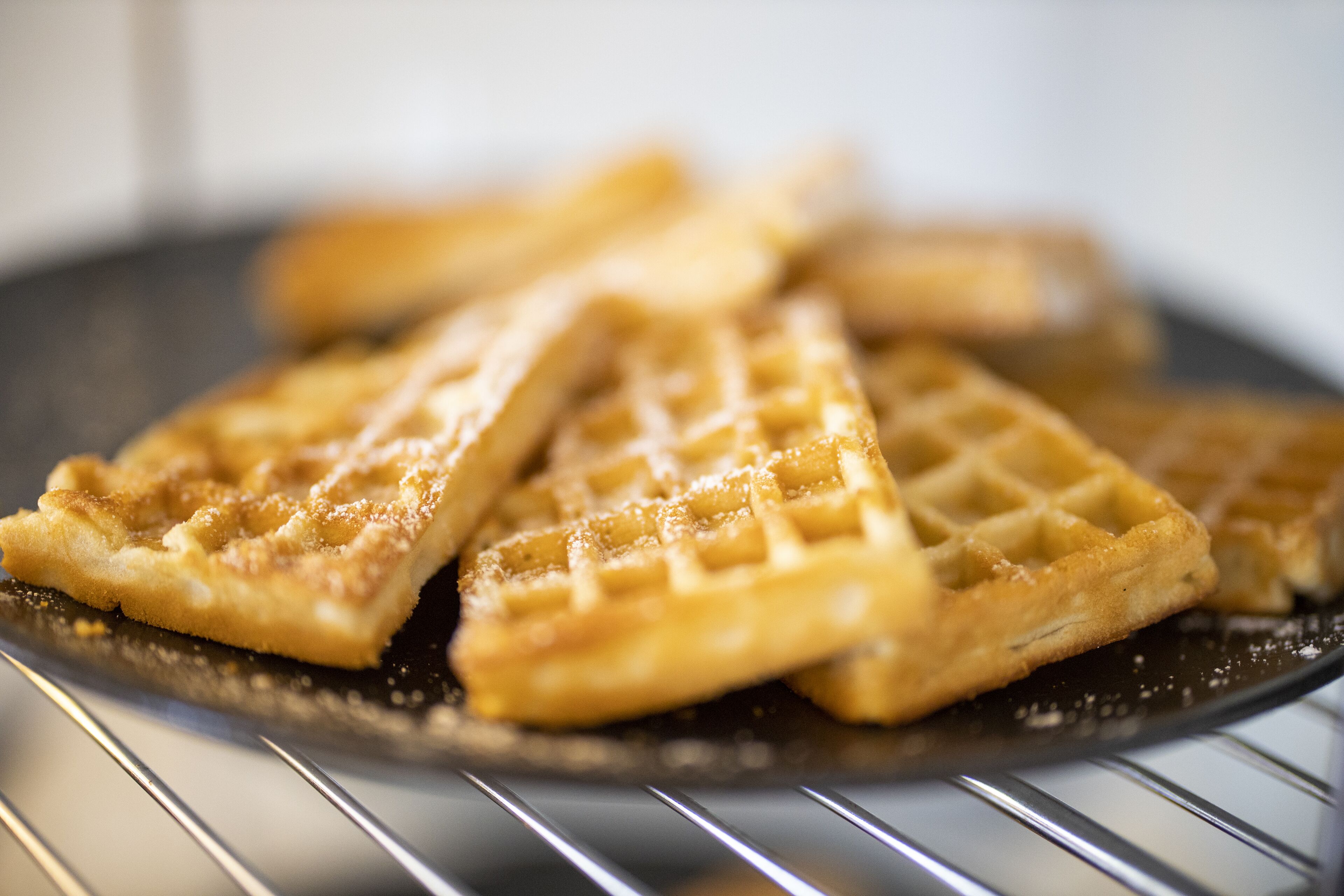 Gros plan sur des gaufres servies dans une assiette noire.