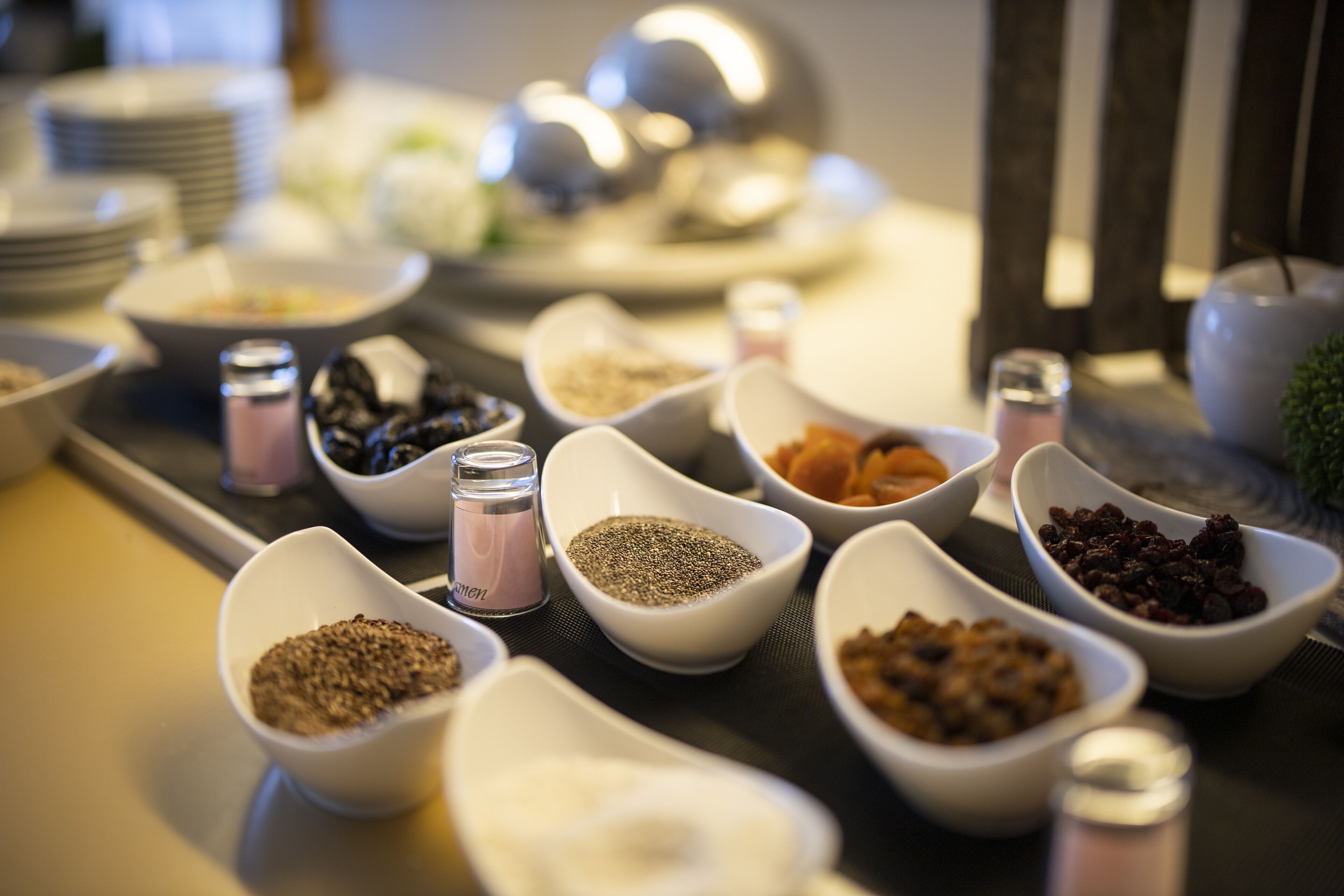 Una mesa con varios recipientes que contienen diferentes alimentos y condimentos.