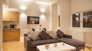 Una sala moderna con un sofá, una mesa de centro y un comedor con mesa y sillas.
