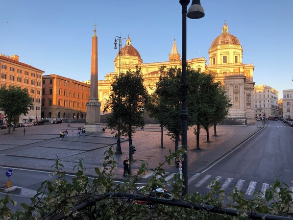 A wide street with a prominent monument and classical architecture in the background. - Basilica Hotel (Rome)