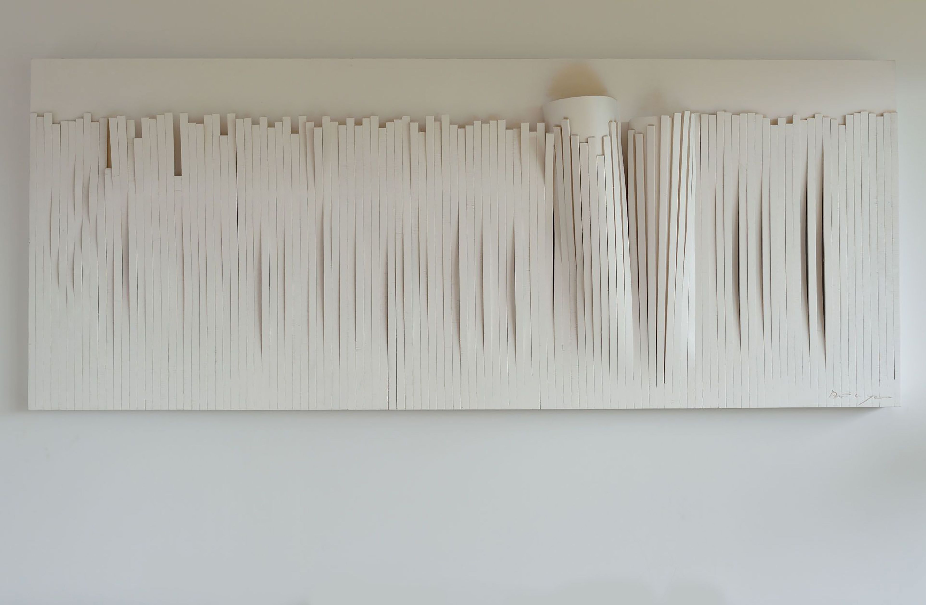 Una gran obra de arte abstracta en blanco sobre una pared lisa.