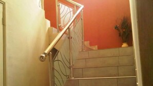 A staircase with metal railings and a potted plant at the top. - Dcove Hotel & Suites (Lagos)