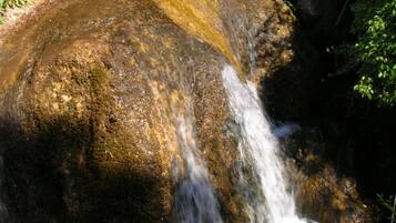 Una formació rocosa natural amb una petita cascada.