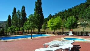 A pool area with lounge chairs and a fenced pool. - Cabañas de Javalambre (Camarena de la Sierra)