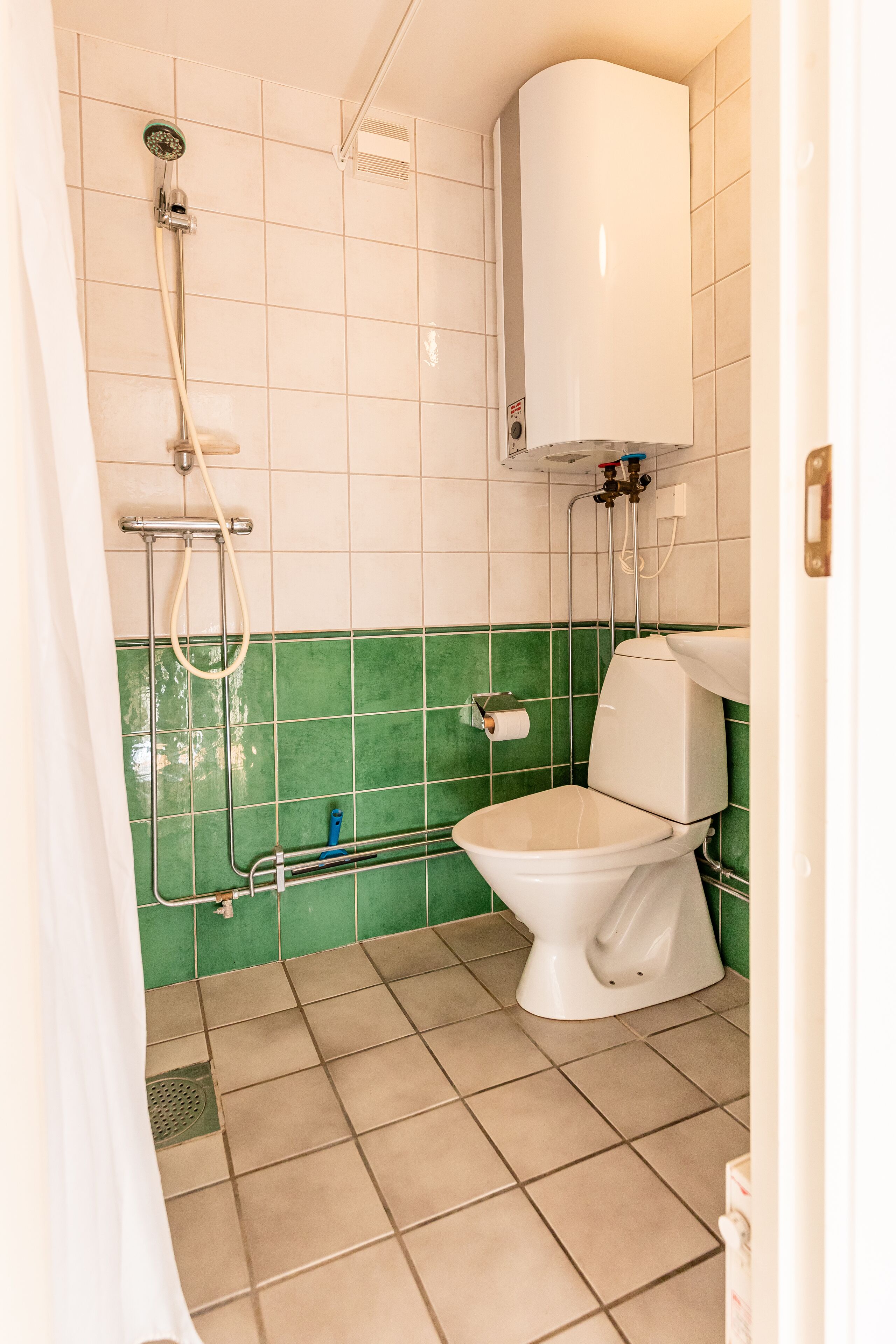 Une salle de bain avec des toilettes, une douche et un lavabo.