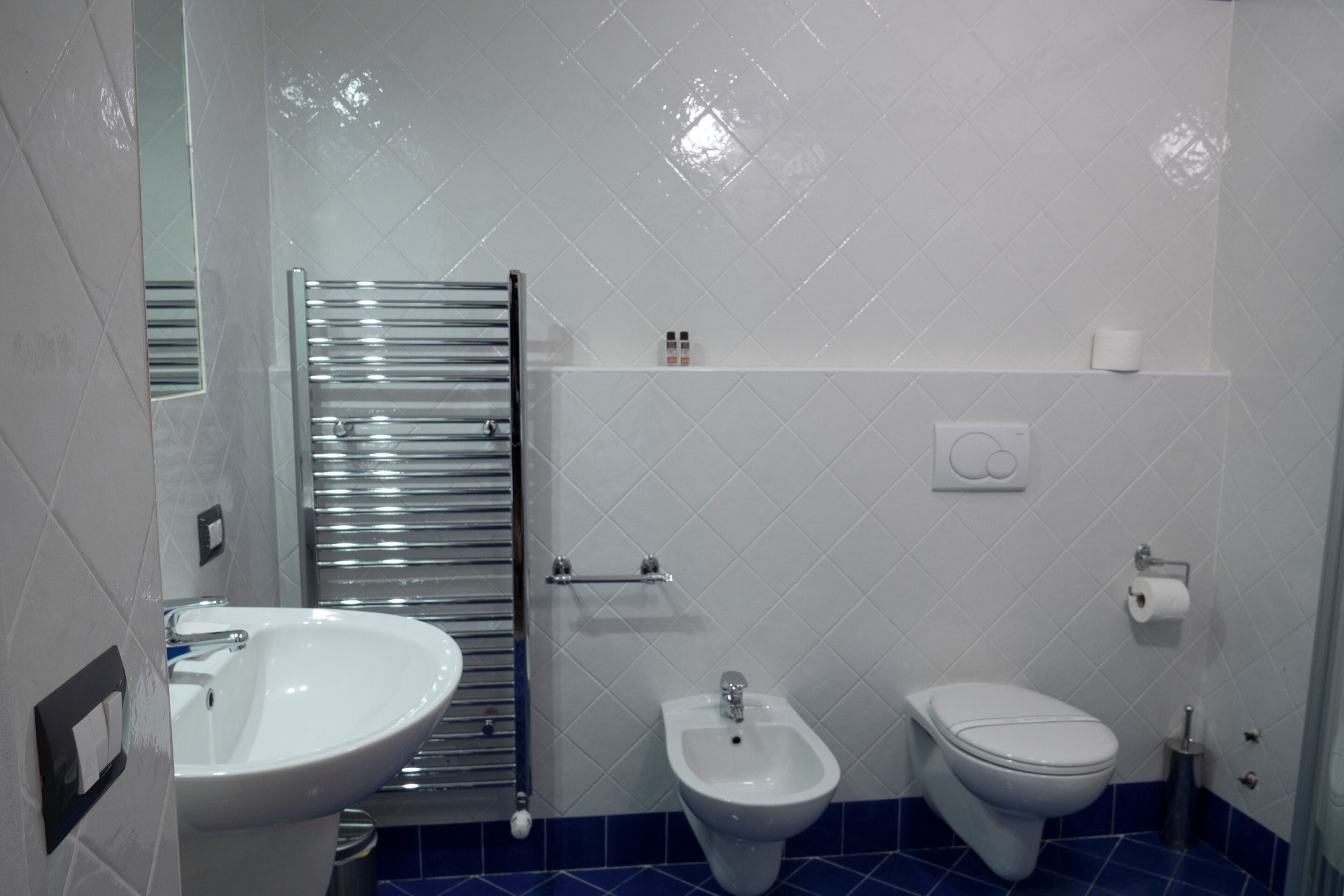 Un baño con un lavamanos blanco, un bidé y un inodoro.