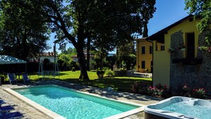 A swimming pool with lounge chairs, a hot tub, and a stone patio. - Agriturismo il Casolare - Villa Vettori (Poppi)