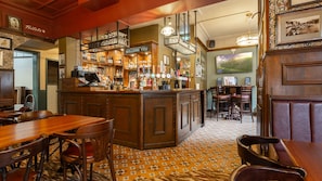 A bar area with a counter, stools, and a patterned floor.