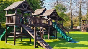 A playground with multiple wooden play structures, including slides and climbing areas. - The Riverside Inn (Bristol)
