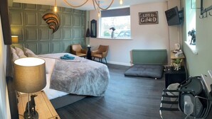 A hotel room with a bed, two chairs, a desk, a bicycle, and a window with a view of the street. - The Riverside Inn (Bristol)