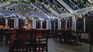 A dining area with a high ceiling, decorated with Christmas lights and ornaments. - The Riverside Inn (Bristol)