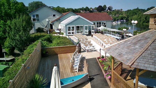 A waterfront property with a patio area, outdoor seating, and a boat dock. - The Riverside Inn (Bristol)