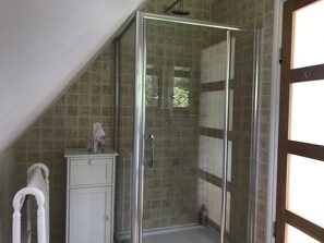 A glass-enclosed shower with a tiled wall, a white cabinet, and a towel rack. - Rosebank Bed & Breakfast (Etchingham)